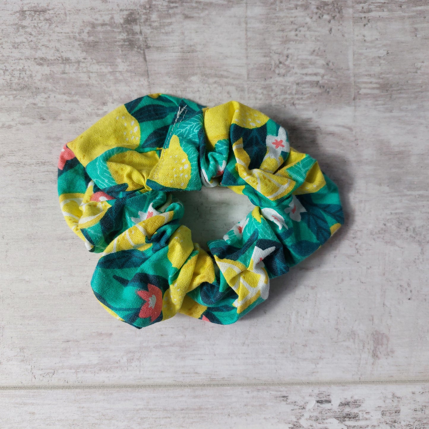 Top view of bold green and yellow Sicilian lemon print hair scrunchie.