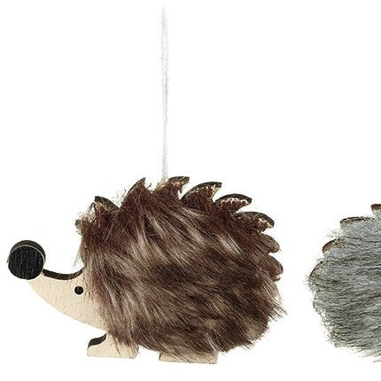 Two hanging hedgehog decorations with faux fur coats and wooden noses.