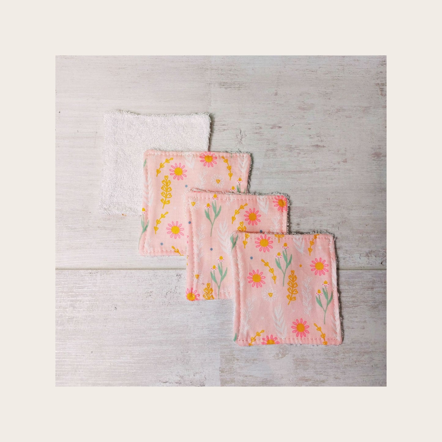 Four pale pink floral print reusable bamboo face wipes by Olganna.