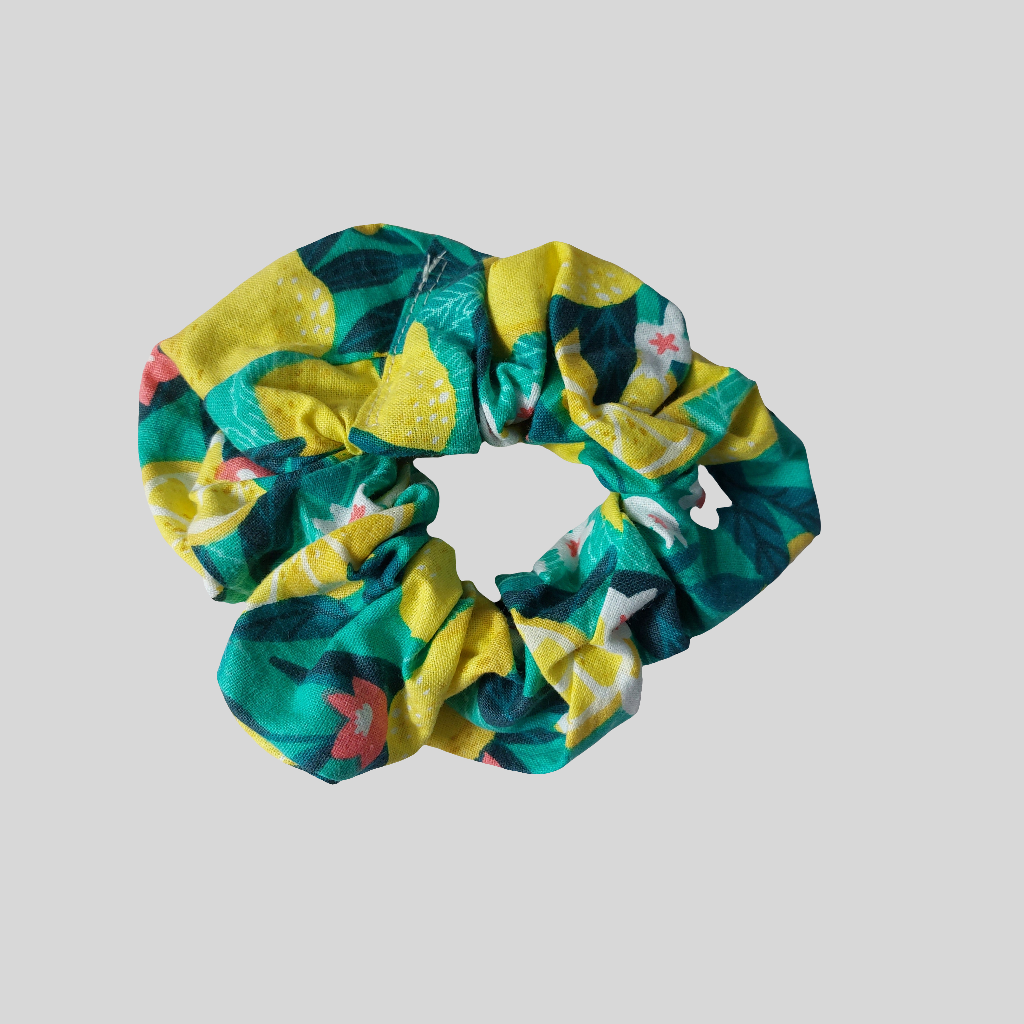 Top view of bold green and yellow Sicilian lemon print hair scrunchie.
