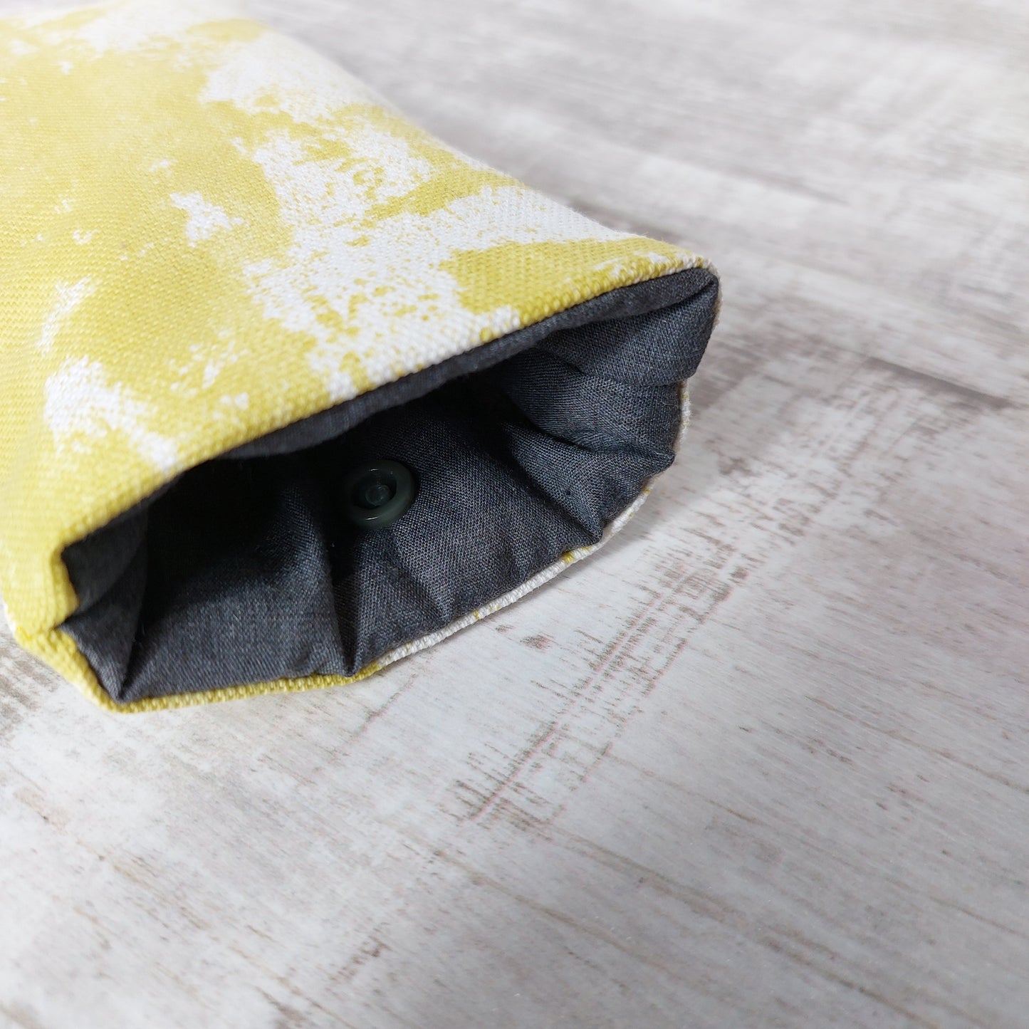 Close-up of bright summer citrus yellow sunglasses case showing padded lining and snap fastening.