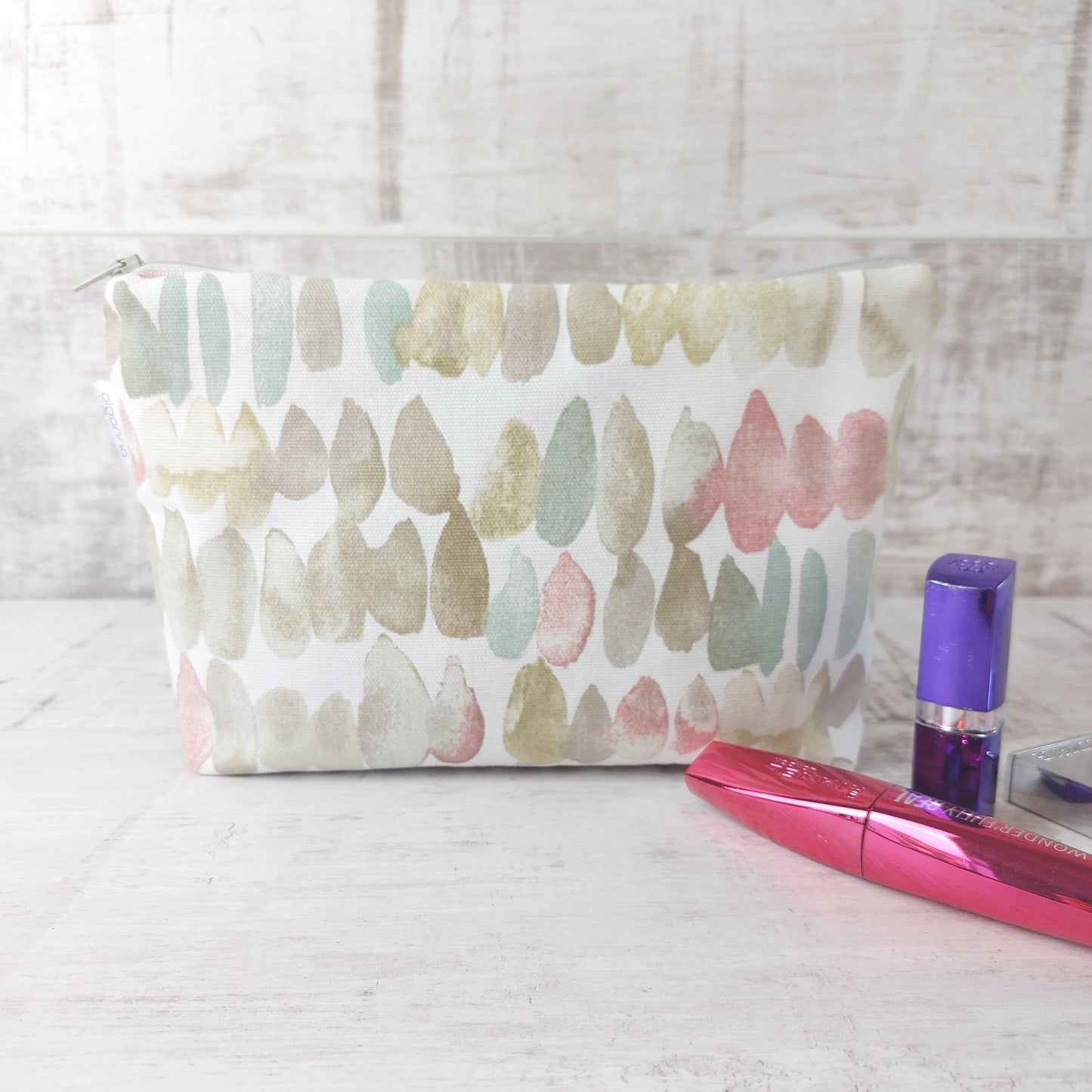 Natural stones print makeup bag pictured with beauty essentials.