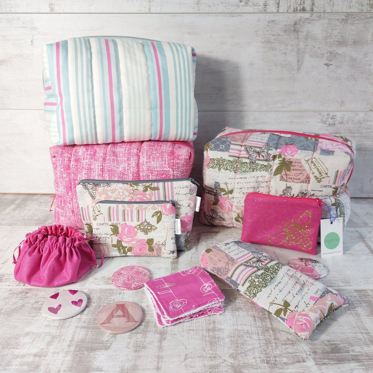 Assorted boxy makeup bags, smaller makeup bags, zip purses, jewellery pouch, compact mirrors, reusable face wipes and a glasses case, all in various pink prints.
