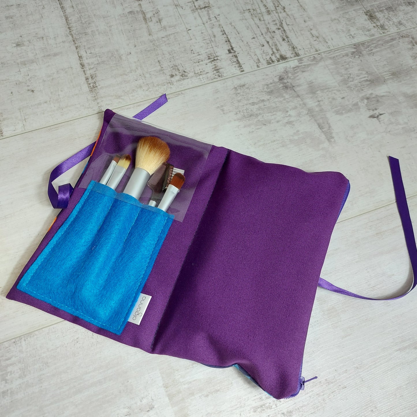 Make up brushes in a purple and turquoise case.