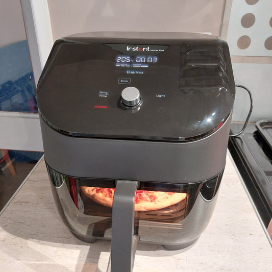 Air Fryer Sat on Kitchen worktop with a pizza cooking inside.