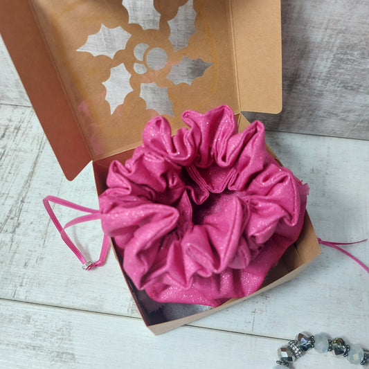 Pink glitter jewellery pouch in an open gift box.