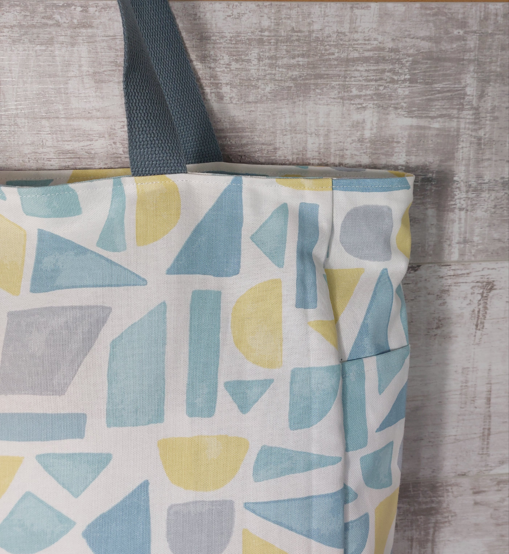 Close-up view of summery pastel print beach bag showing outer pocket.