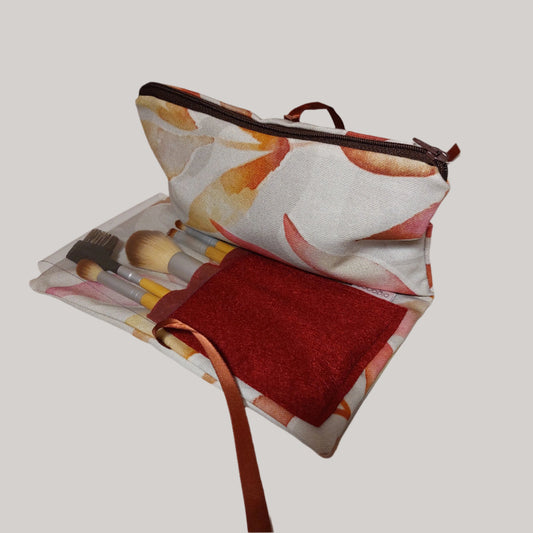 Zip fastening make up case and brushes in autumn leaf fabric in marble bathroom.