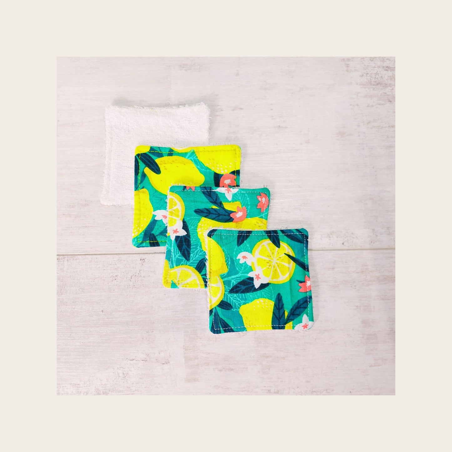 Four bamboo face wipes overlapping, in bold green and yellow Sicilian lemon print. 