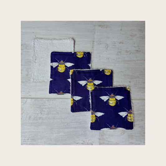 Four bamboo face wipes overlapping, in navy bee print. 
