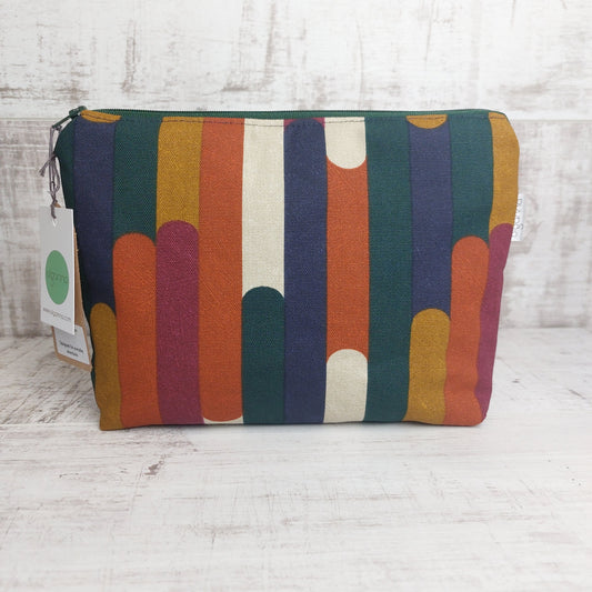 Toiletries zip bag in an autumn shades stripe pattern with Olganna gift tags.