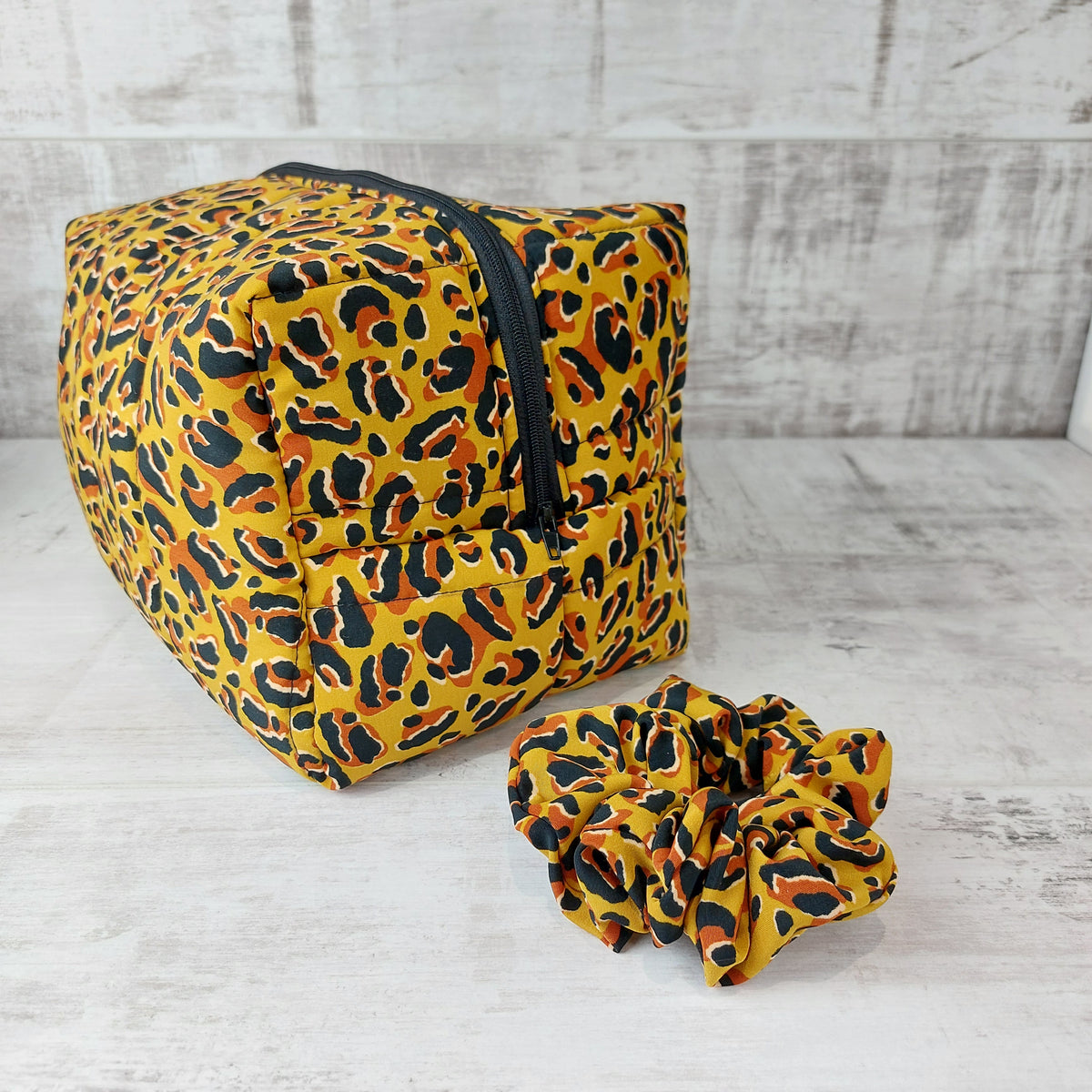 Large boxy makeup bag in leopard print with matching leopard print scrunchie.
