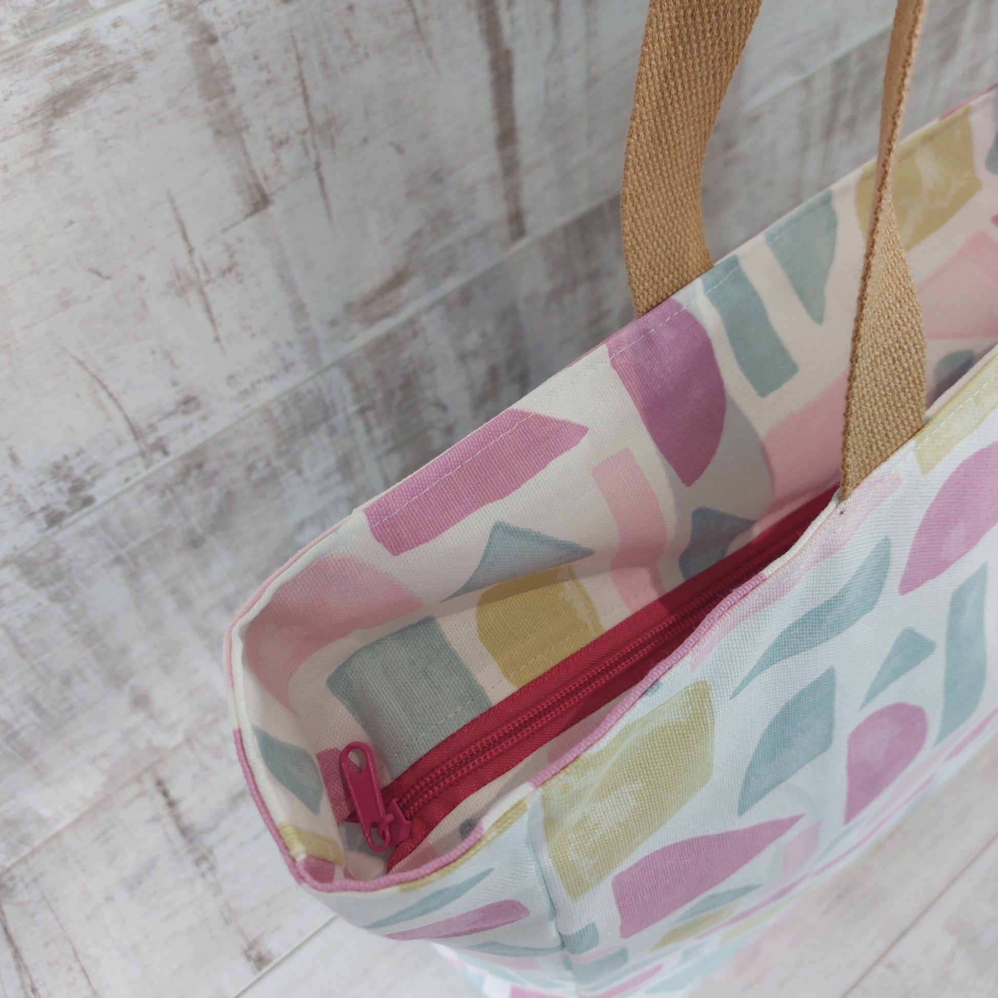 Top view of pink pastels summery beach bag showing deep-set zip closure.