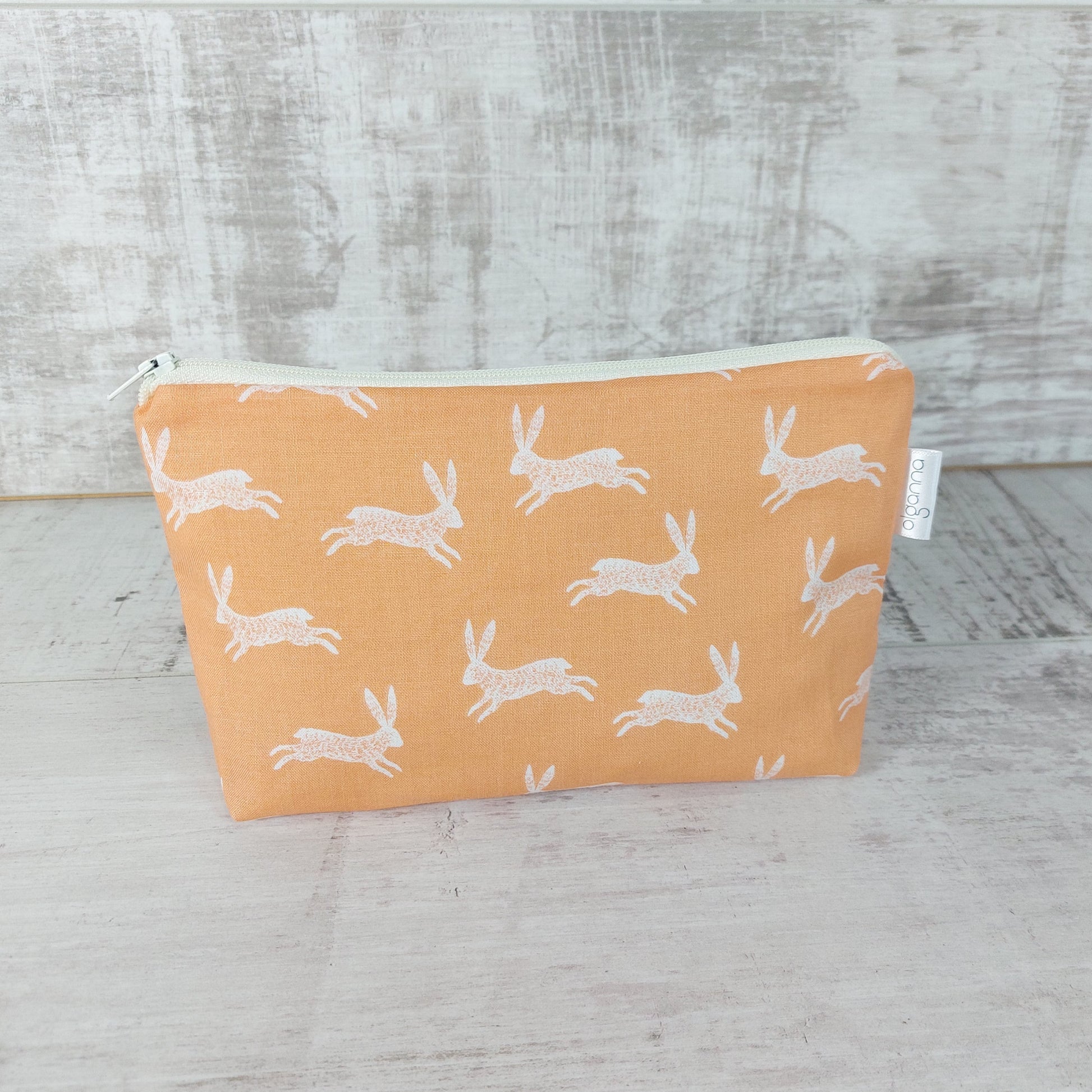 Front view of pale gold bunny print makeup bag. 