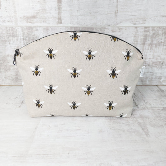 Large makeup bag with repeat bee print on linen-look fabric, front view.