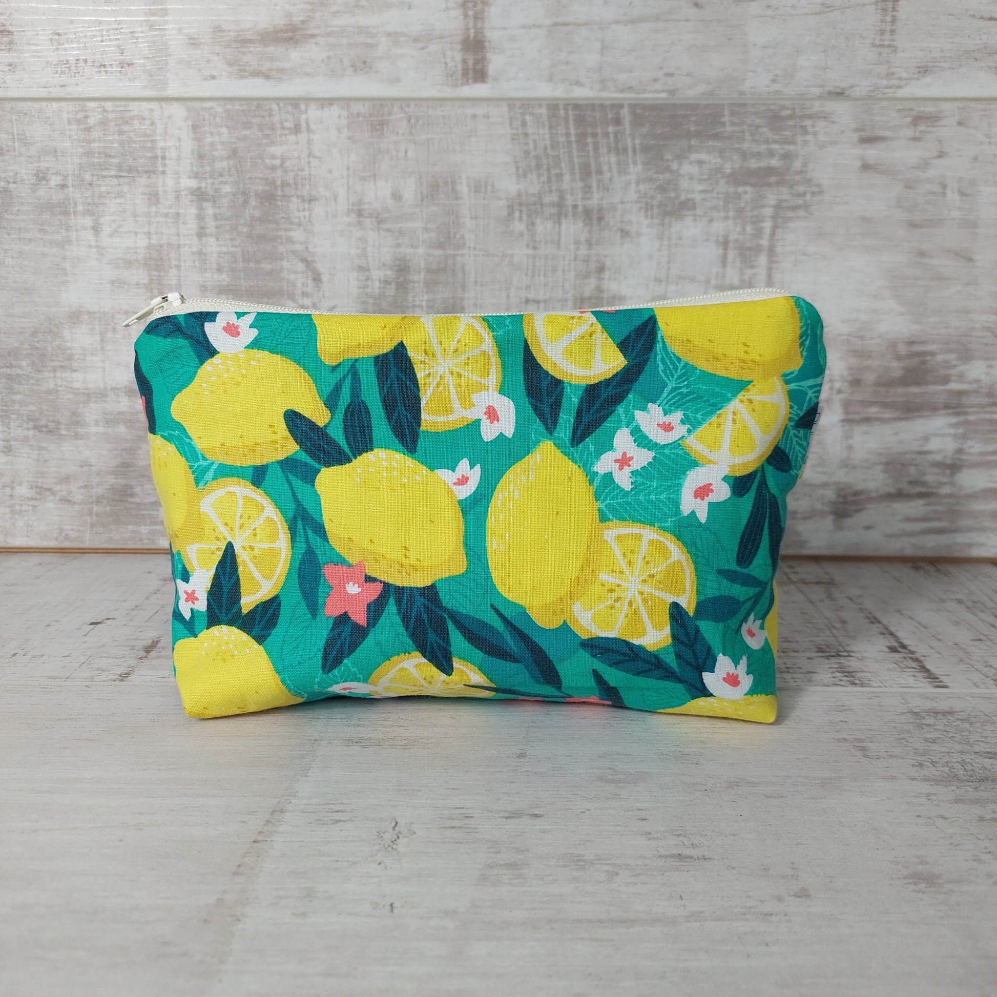 Front view of bold green and yellow Sicilian lemon print makeup bag. 