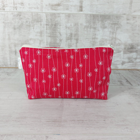 Front view of red and white flower print makeup bag. 