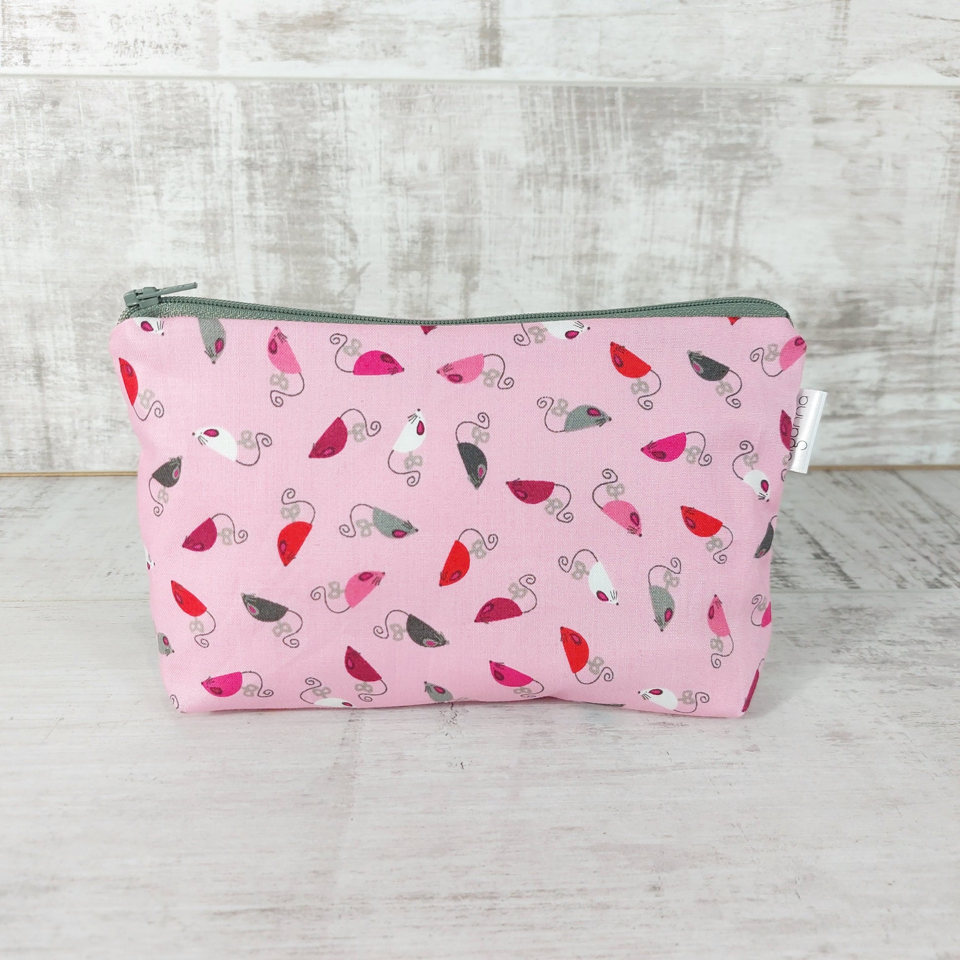 Front view of pink mice print makeup bag. 