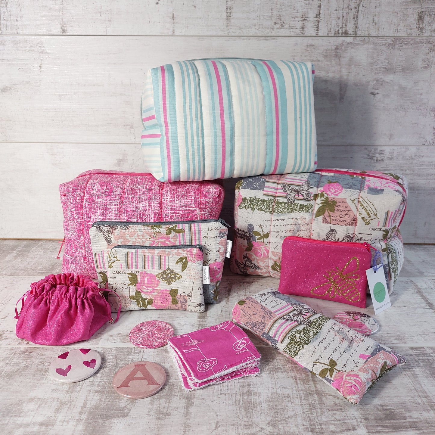 Assorted boxy makeup bags, smaller makeup bags, zip purses, jewellery pouch, compact mirrors, reusable face wipes and a glasses case, all in various pink prints.