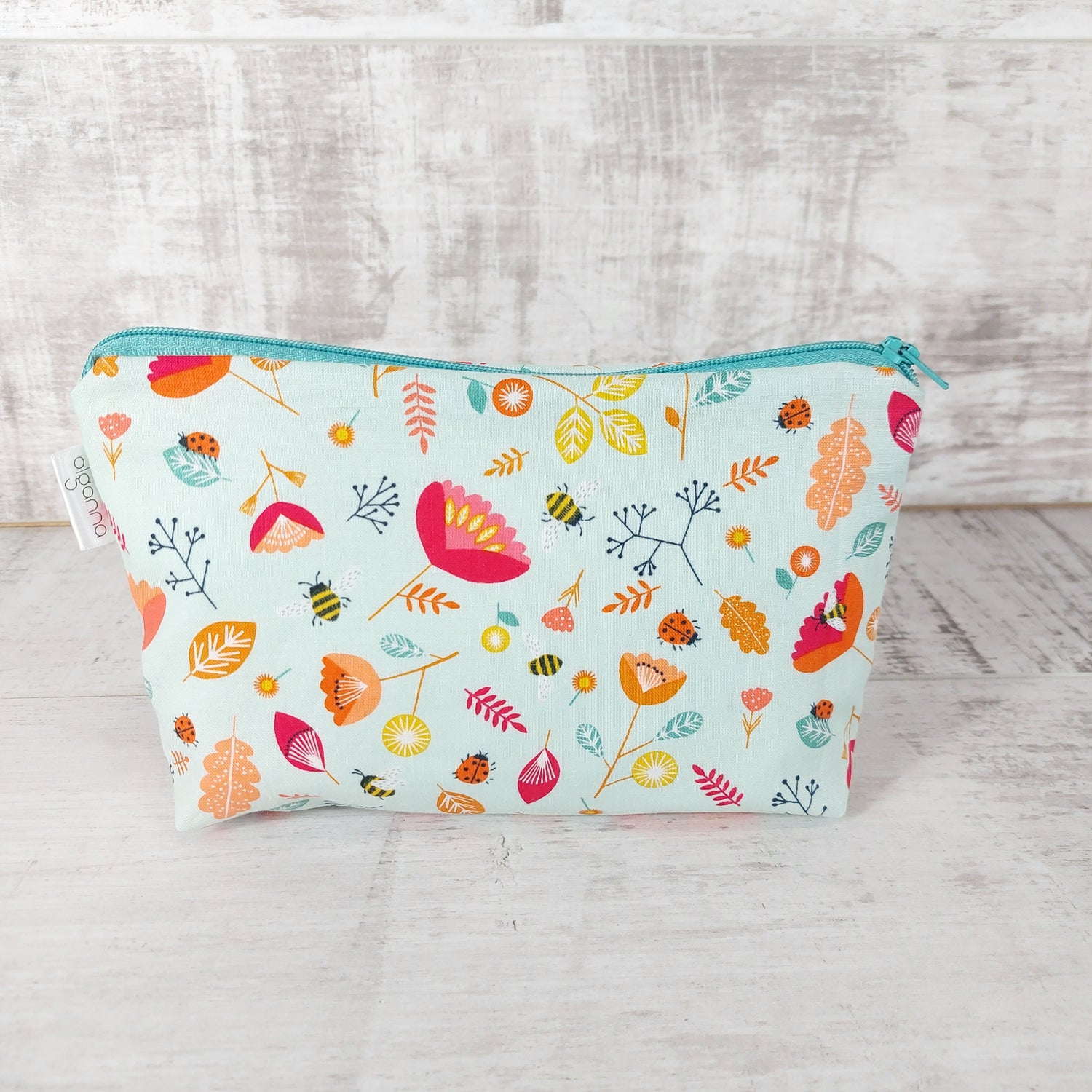 Front view of Spring floral and insect print makeup bag. 