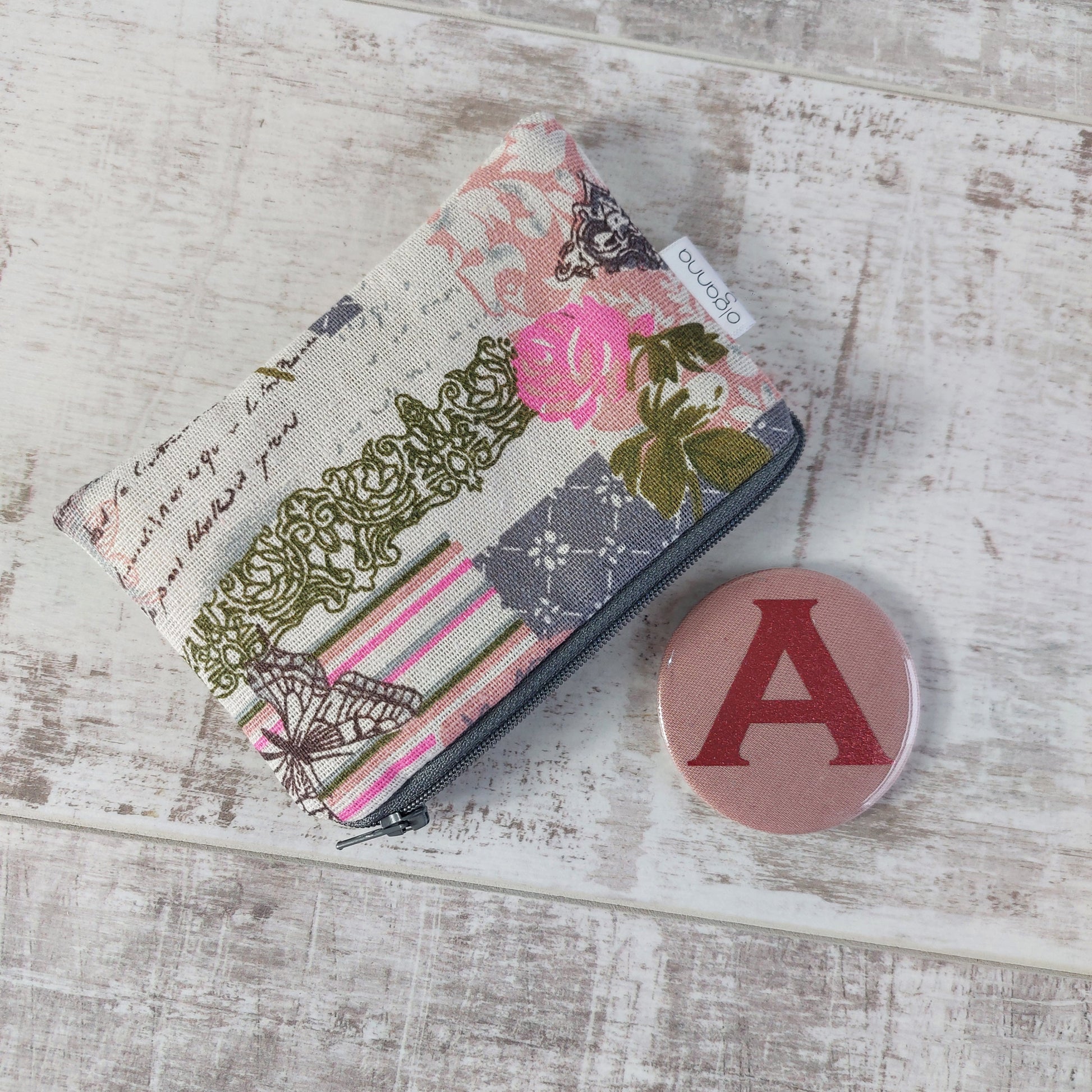 Floral vintage-style print zip purse in a soft pink Paris-inspired design, pictured with a pink compact mirror backed with a sparkly letter A.