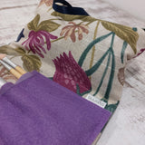 Close up of the flowery fabric on the Olganna make up bag and label showing