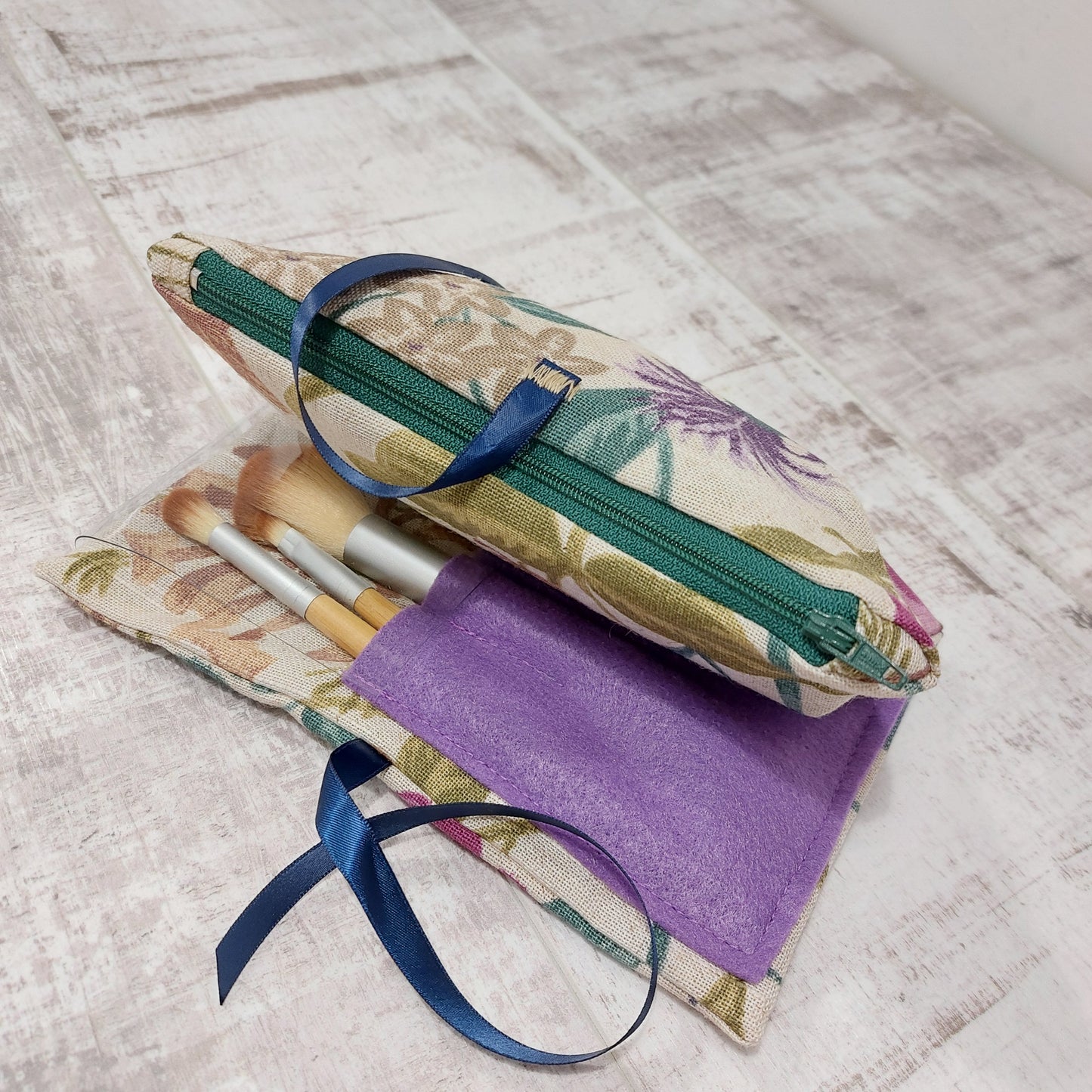 floral pattern make up bag with lilac coloured brushes pocket, brushes in the pocket and navy ribbon ties