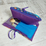 Make up brushes in a purple and turquoise case.