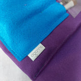 Close up of turquoise felt brushes pocket on purple make up bag.