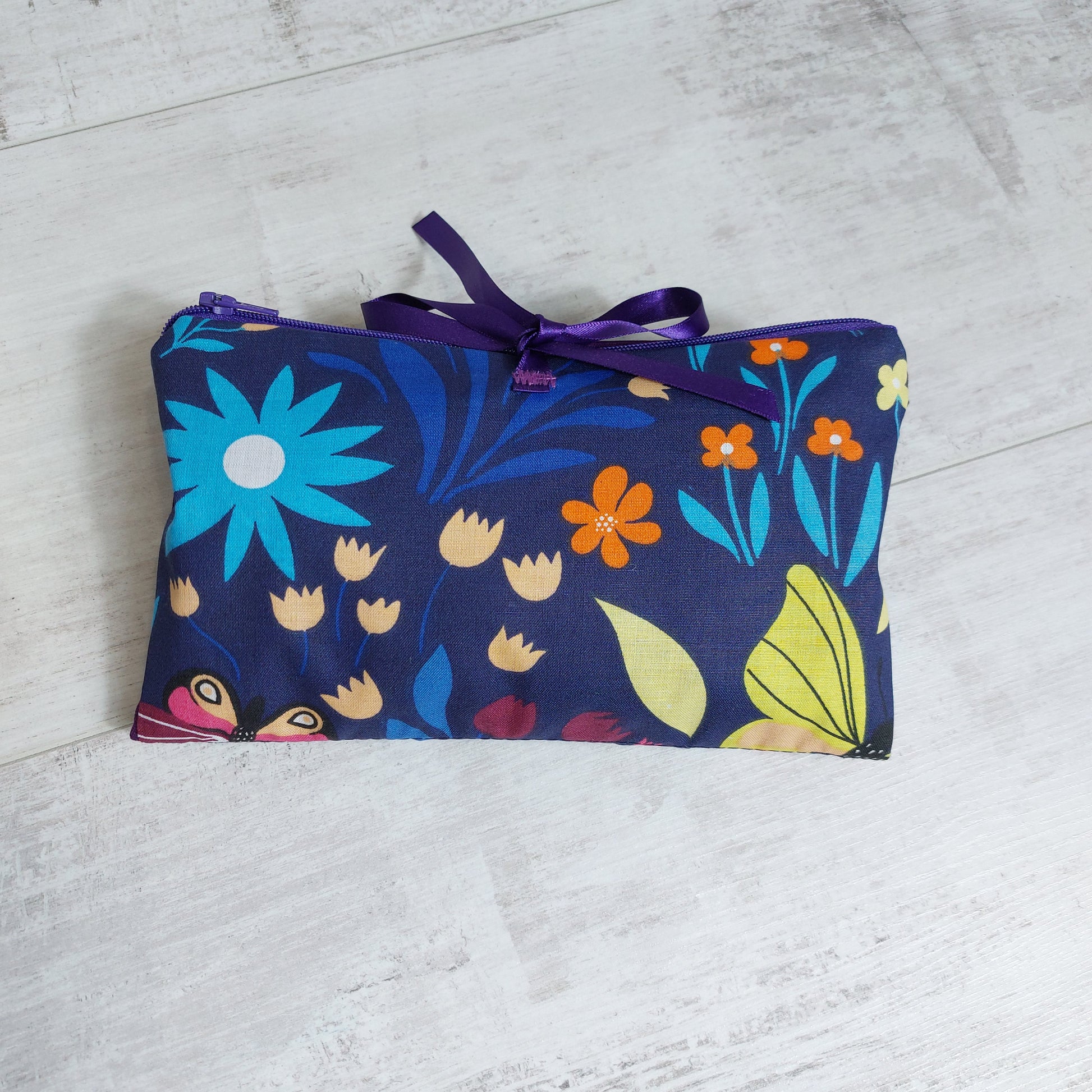 Floral make up bag with ribbon ties. Navy with bright colour pops and purple.